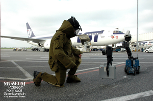 1. Tytuł tematu: służba graniczna
2. Opis obrazu: pirotechnik z Nadwiślańskiego Oddziału Straży Granicznej podczas służby na lotnisku Warszawa Okęcie
3. Data wydarzenia: 09.10.2006 r.
4. Osoby widoczne: brak danych
5. Hasła przedmiotowe: Straż Graniczna, ochrona fizyczna
6. Opis techniczny: zdjęcie cyfrowe, kolorowe
7. Autor: brak danych
8. Miejsce przechowywania/właściciel: Archiwum Straży Granicznej w Szczecinie