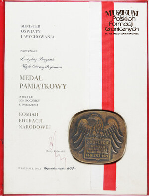 1. Tytuł: medal pamiątkowy z okazji 200 rocznicy utworzenia Komisji Edukacji Narodowej
2. Treść: medal przyznany Łużyckiej Brygadzie WOP przez Ministra Oświaty i Wychowania (wraz z aktem nadania)
3. Hasło przedmiotowe: Wojska Ochrony Pogranicza, przedmioty pamiątkowe
4. Wytwórca: Minister Oświaty i Wychowania
5. Czas powstania: 1974 r.
6. Miejsce sporządzenia: Polska, Warszawa
7. Materiał i technika wykonania: medal – tombak oksydowany, akt nadania - papier, druk
8. Wymiary: 30 x 22 cm
9. Stan zachowania: bardzo dobry
10. Miejsce przechowywania/ właściciel: depozyt Sali Tradycji Ośrodka Szkoleń Specjalistycznych SG w Lubaniu