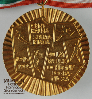 1.Nazwa własna: medal pamiątkowy
2.Charakterystyka przedmiotu: złoty medal o średnicy 7 cm na wstędze w kolorach: zielonym, białym i czerwonym. Awers: symboliczny zarys mapy Polski, na której przedstawiono sylwetki sportowców oraz   napis „Centralna Spartakiada, 1945-1985, 40 lat Wojsk Ochrony Pogranicza”. Rewers: pusty.
3.Czas powstania: 1985 r.
4.Hasła przedmiotowe: Wojska Ochrony Pogranicza, przedmioty pamiątkowe
5.Miejsce przechowywania/ właściciel: depozyt Sali Tradycji Ośrodka Szkoleń Specjalistycznych SG w Lubaniu