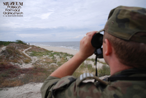 1. Tytuł tematu: patrol graniczny
2. Opis obrazu: funkcjonariusz z Placówki Straży Granicznej w Krynicy Morskiej podczas obserwacji wybrzeża 
3. Data wydarzenia: 16.07.2008 r. 
4. Osoby widoczne: brak danych
5. Hasła przedmiotowe: Straż Graniczna, ochrona fizyczna
6. Opis techniczny: zdjęcie cyfrowe, kolorowe 
7. Autor: Krzysztof Niemiec 
8. Miejsce przechowywania/właściciel: Archiwum Straży Granicznej w Szczecinie