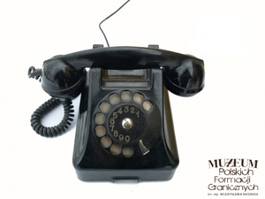 1. Nazwa własna: aparat telefoniczny CB - 49
2. Charakterystyka przedmiotu: obudowa aparatu, mikrotelefonu oraz wszystkie części zewnętrzne wykonane są z bakelitu koloru czarnego (powstawały też krótkie serie aparatów CB 49 w kolorach czerwonym i zielonym). Produkowany w Radomskiej Wytwórni Telefonów. W 1949 roku rozpoczęto prace nad nowym modelem, który miał zastąpić licencyjnego CB 47. Aparaty serii 49 zostały zaprojektowane do współpracy z łącznicami telefonicznymi centralnej baterii zarówno ręcznymi, jak i automatycznymi, o zasilaniu napięciem 24, 50 albo 60 V. Numer katalogowy serii oznaczono symbolami od AT-05 do AT-12(cztery ostatnie serie były przystosowane do przyłączenia dzwonka dodatkowego)
3. Czas powstania: 1949 r.
4. Hasła przedmiotowe: Wojska Ochrony Pogranicza, łączność
5. Miejsce przechowywania/właściciel: Nadbużański Oddział Straży Granicznej w Chełmie