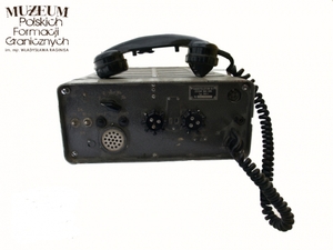 1. Nazwa własna: radiotelefon bazowy K - 1
2. Charakterystyka przedmiotu: radiotelefon przystosowany do pracy stacjonarnej, montowany między innymi na samochodach. Konstrukcja lampowa, w której zastosowano lampy ze złoconymi nóżkami. Moc wyjściową uzyskiwano na lampie GU – 50. W zestaw radiotelefonu K-1 wchodziły: blok nadawczo odbiorczy, zasilacz sieciowy, zasilacz bateryjny z akumulatora 12V, zasilacz do ładowania akumulatorów 12V, rozwidlenie telefoniczne, kable połączeniowe, mikrotelefon, maszt teleskopowy 10 m z odciągami, antena prętowa z przeciwwagą, miernik kontrolny napięcia i mocy wyjściowej w antenie. Zakres częstotliwości: dolny 78,275 - 77,726 MHz, górny 85,075 - 87,525 MHz, 100 ustalonych fal roboczych (00 do 99), moc 25 W, zasięg do 40 km (w ruchu do 10 km), łącze ruchome z blokadą szumów 10 km i bez niej do 18 km, łącze półstacjonarne z blokadą szumów 15 km i bez niej do 25 km, łącze stacjonarne z blokadą szumów 34 km i bez niej do 40 km, zasilanie z zasilacza sieciowego 220V lub bateryjnego (akumulatory) 12,6 V, praca z mikrotelefonu lub linii zewnętrznej poprzez rozwidlenie radiotelefoniczne, możliwość pracy simpleks lub dupleks (na 2 różnych falach różniących się o 50 numerów), 
3. Czas powstania: przed 1991 r.
4. Hasła przedmiotowe: Wojska Ochrony Pogranicza, łączność 
5. Miejsce przechowywania/właściciel: Nadbużański Oddział Straży Granicznej w Chełmie
