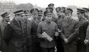 1. Tytuł tematu: szkolenie prokuratorów Wojska Polskiego
2. Opis obrazu: oficerowie Wojsk Ochrony Pogranicza i prokuratorzy wojskowi na cmentarzu w Siekierkach
3. Data wydarzenia: 1965 r.
4. Osoby widoczne: brak danych
5. Hasła przedmiotowe: Wojska Ochrony Pogranicza, szkolenie
6. Opis techniczny: oryginał, czarnobiałe
7. Autor: brak danych
8. Miejsce przechowywania/właściciel: Zbigniew Nowicki