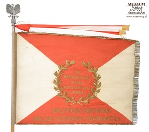 1.Nazwa własna: sztandar Bałtyckiej Brygady Wojsk Ochrony Pogranicza.
2.Charakterystyka przedmiotu: biały płat (130 x 100 cm) zszyty z dwóch trójkątów koloru białego (bocznych) i dwóch koloru czerwonego (górny i dolny). Pośrodku, na czerwonym tle  obwiedzionym dwiema złotymi gałązkami wawrzynu, umieszczono wizerunek orła państwowego. Na stronie odwrotnej widnieje napis, otoczony gałązkami wawrzynu „Za – Naszą Ojczyznę – Polską – Rzeczpospolitą – Ludową”, a poniżej nazwa jednostki: „Bałtycka Brygada – Wojsk Ochrony Pogranicza”. Płat sztandaru obszyty złotymi frędzlami
3.Czas powstania: 1963 r.
4.Hasła przedmiotowe: Wojska Ochrony Pogranicza, sztandary
5.Miejsce przechowywania/ właściciel: Centralny Ośrodek Szkolenia Straży Granicznej w Koszalinie